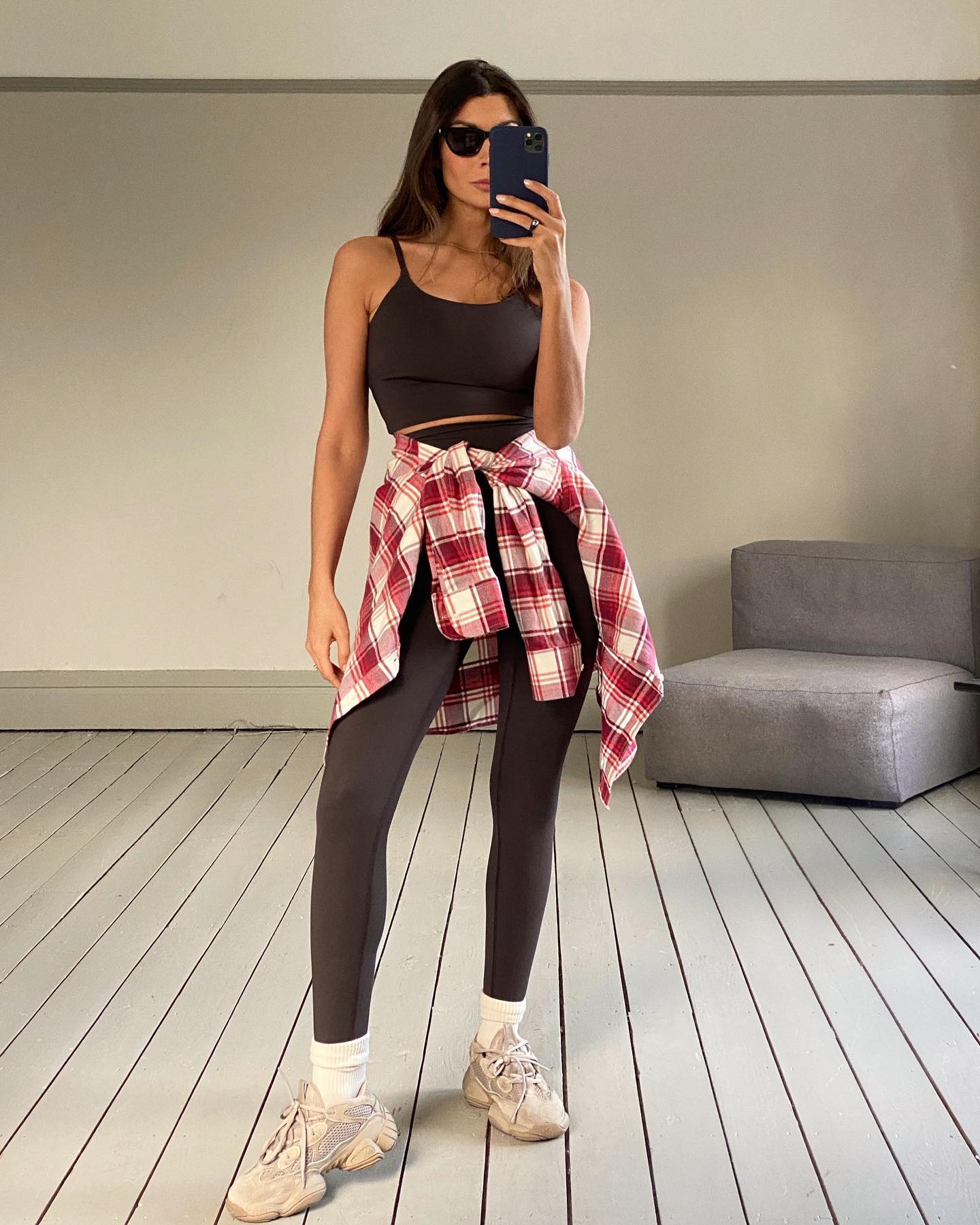 An image of @smythsisters wearing brown leggings with a red flannel shirt.