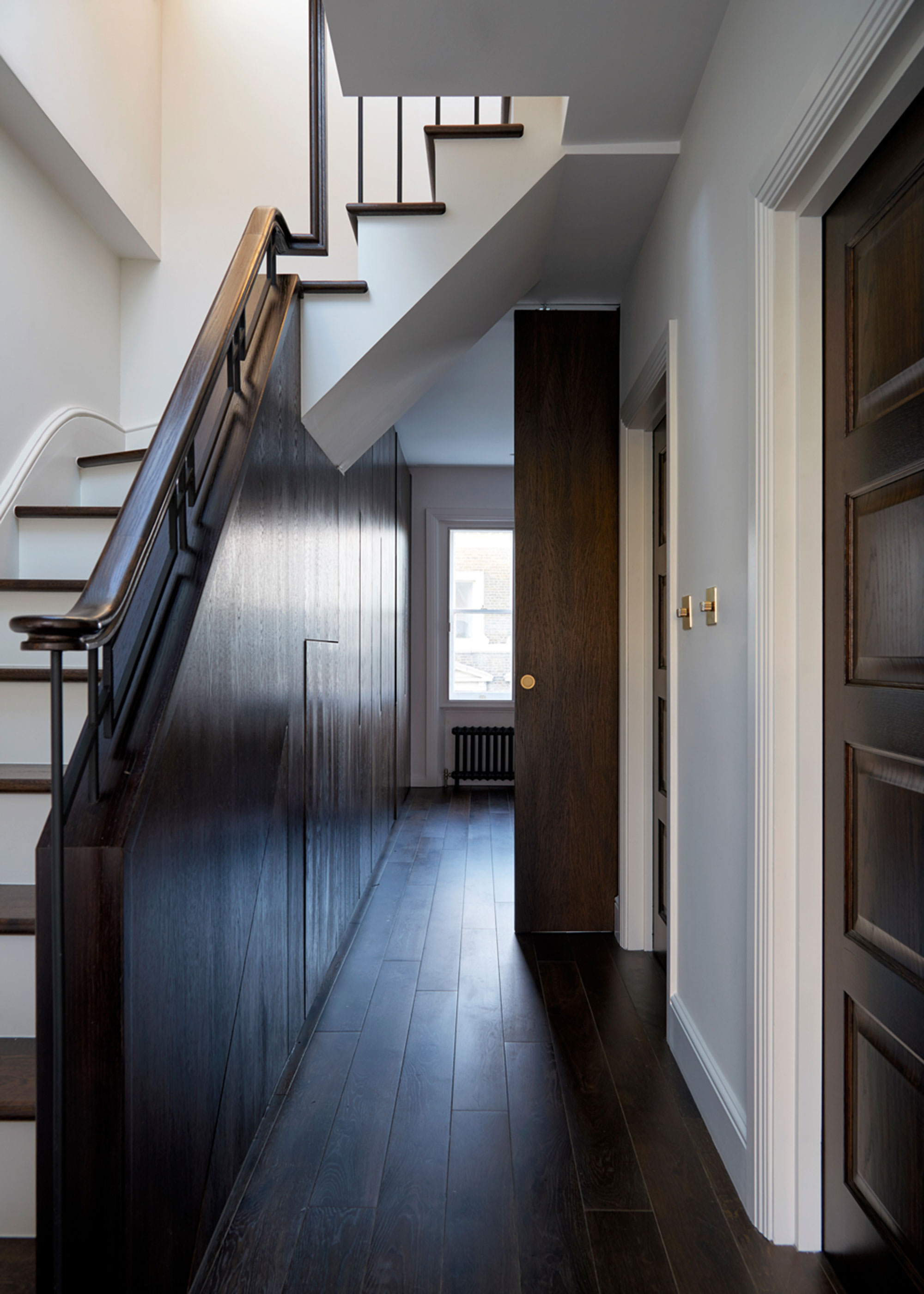 entrance hall in period house with dark wood flooring and wall panelling