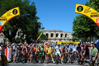 The riders line up for the start of stage 14 of the 2008 Tour de France with the spectacular Arena of Nimes behind them.