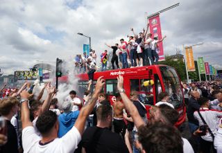 England fan stand on a bus