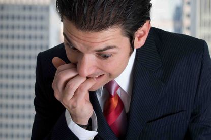 a worrying man biting his fingerails