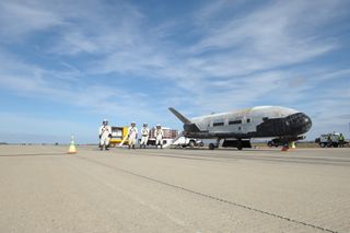 The U.S. Air Force's mysterious X-37B unmanned space plane is serviced by a ground crew after successfully landing at Vandenberg Air Force Base in California on Oct. 17, 2014. The landing wrapped up a record-breaking 674-day spaceflight for the winged min