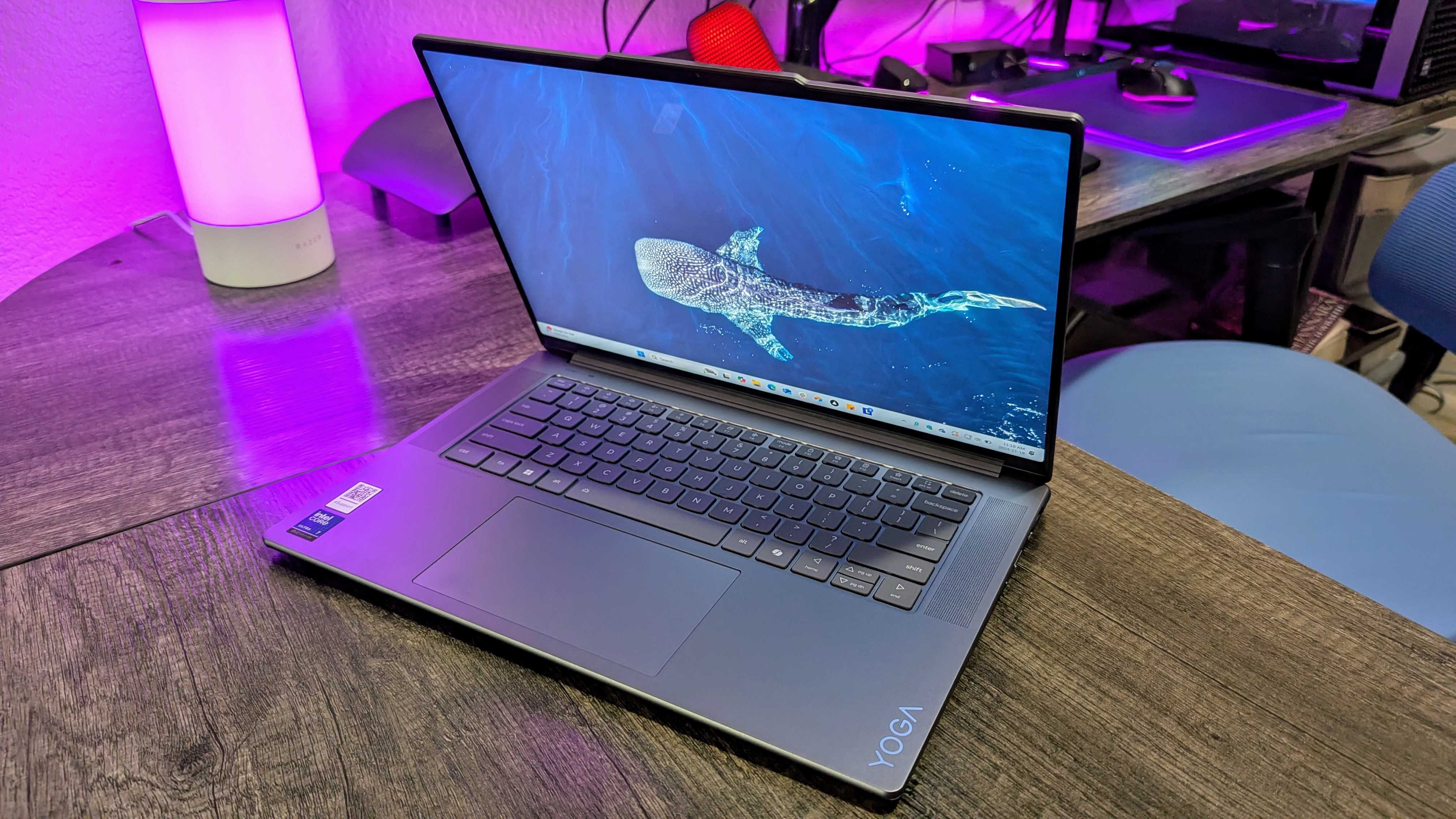 The Lenovo Yoga Slim 7i (Gen 9) Aura Edition on a desk with its screen slightly facing down.