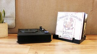 the victrola revolution go turntable with the dust cover being used as a record stand