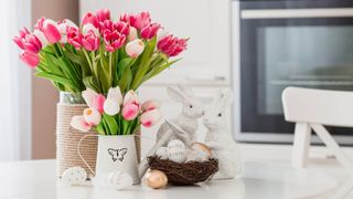 Bouquet of flowers and Easter decorations on white kitchen table
