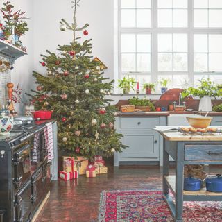 Country-style kitchen with real christmas tree in the corner and blue cabinets