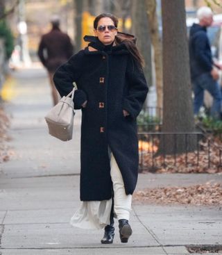 A photo of Katie Holmes wearing a hooded black Forte Forte coat for a post-Thanksgiving stroll in New York City.