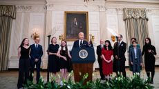 President Joe Biden, center, joined by relatives of freed Russian prisoners, in the State Dining Room of the White House on August 1, 2024