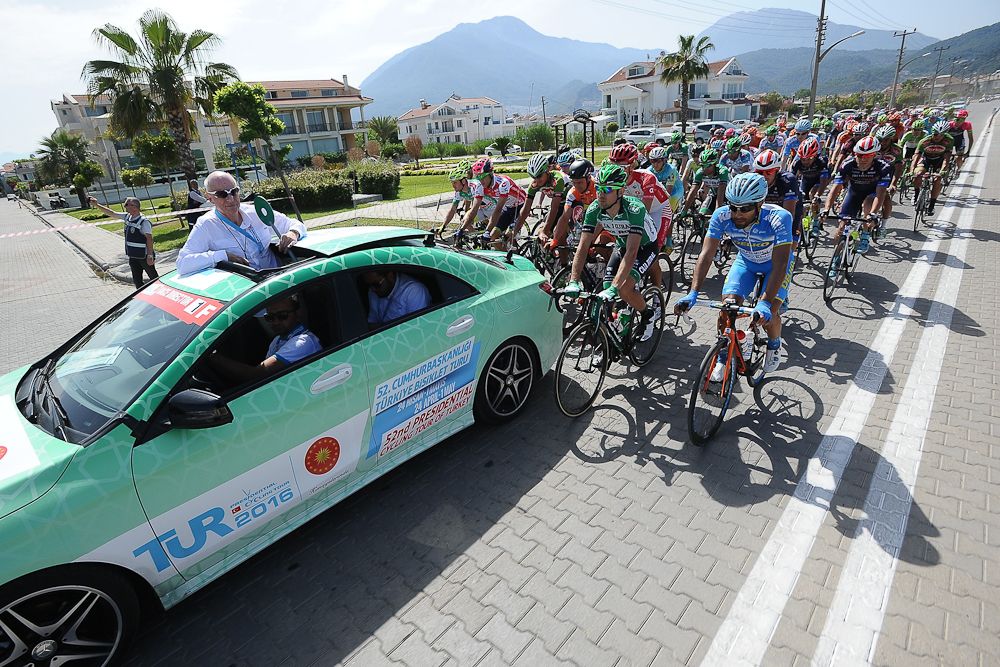 Riders wait behind the official vehicle for the neutral start.
