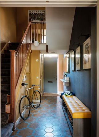 Hallway shoe storage ideas with a yellow bench in a blue hallway