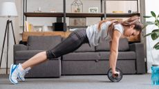 Woman at home doing an abs wheel plank 