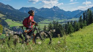 Woman with electric mountain bike in scenic valley