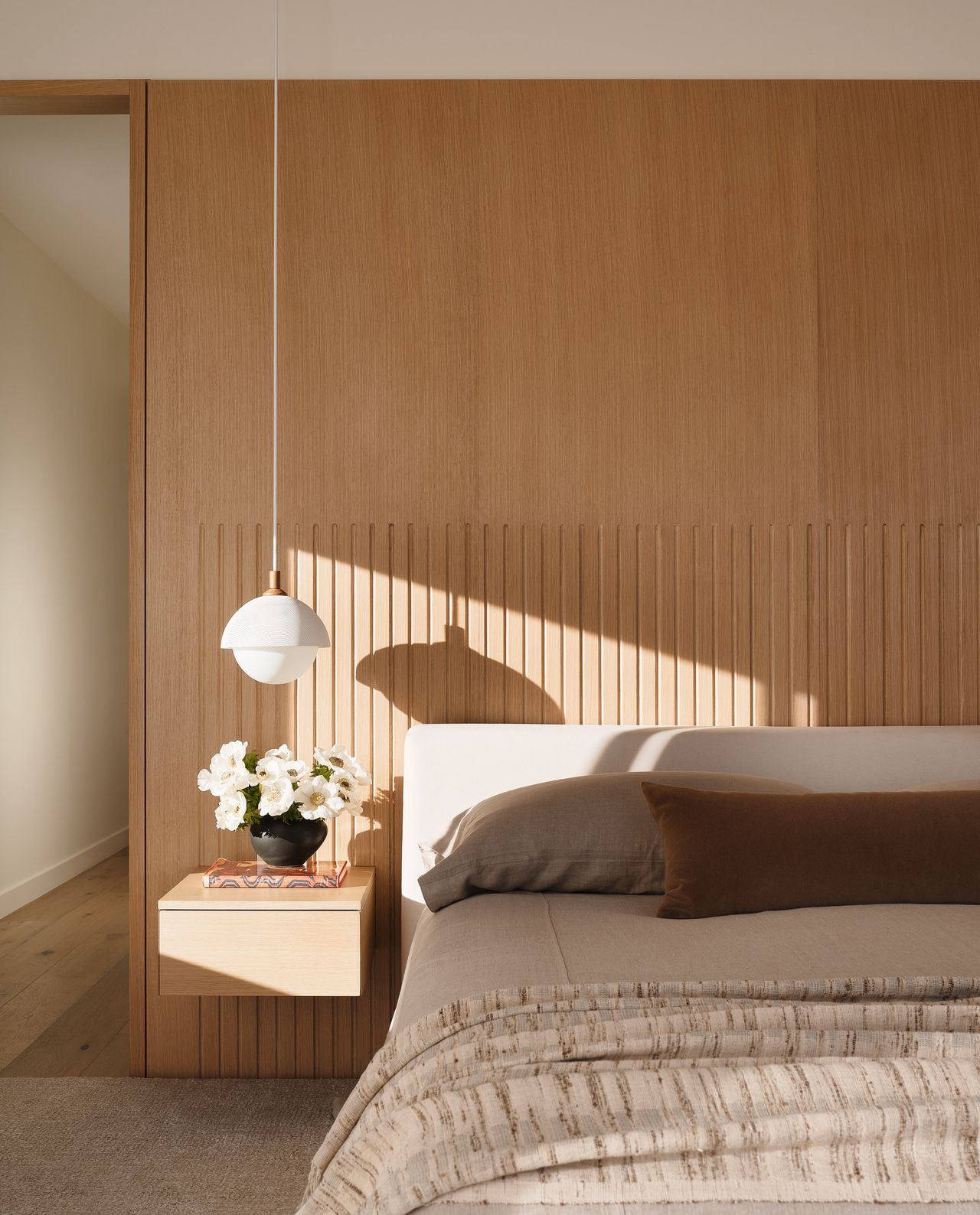 a bedroom with a slatted style headboard