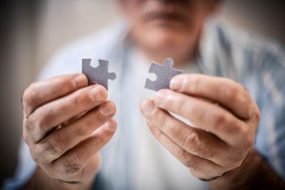 A man holding a puzzle piece 