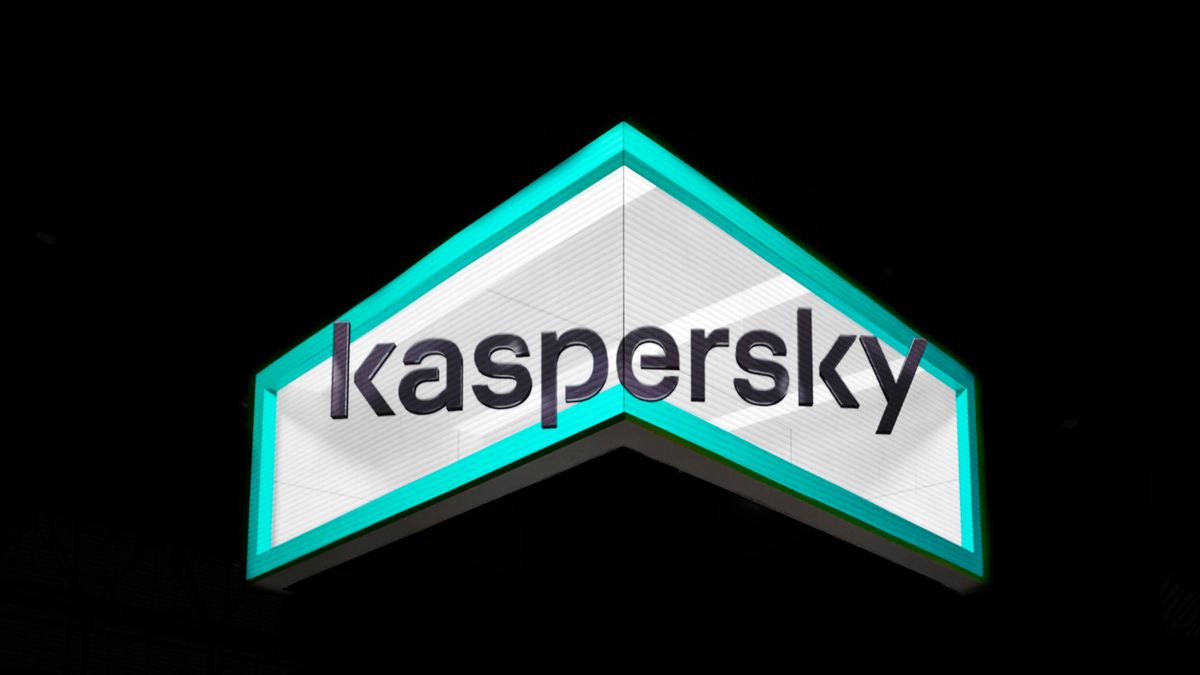 The Kaspersky logo on a stand at Mobile World Congress 2023, shot from below. It is grey text against a green border, set on a dark background,