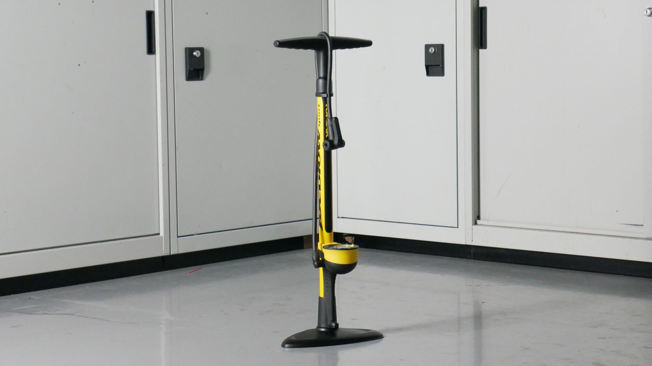 Topeak JoeBlow Sport III bike track pump in Yellow set against a background of some workshop cabinets