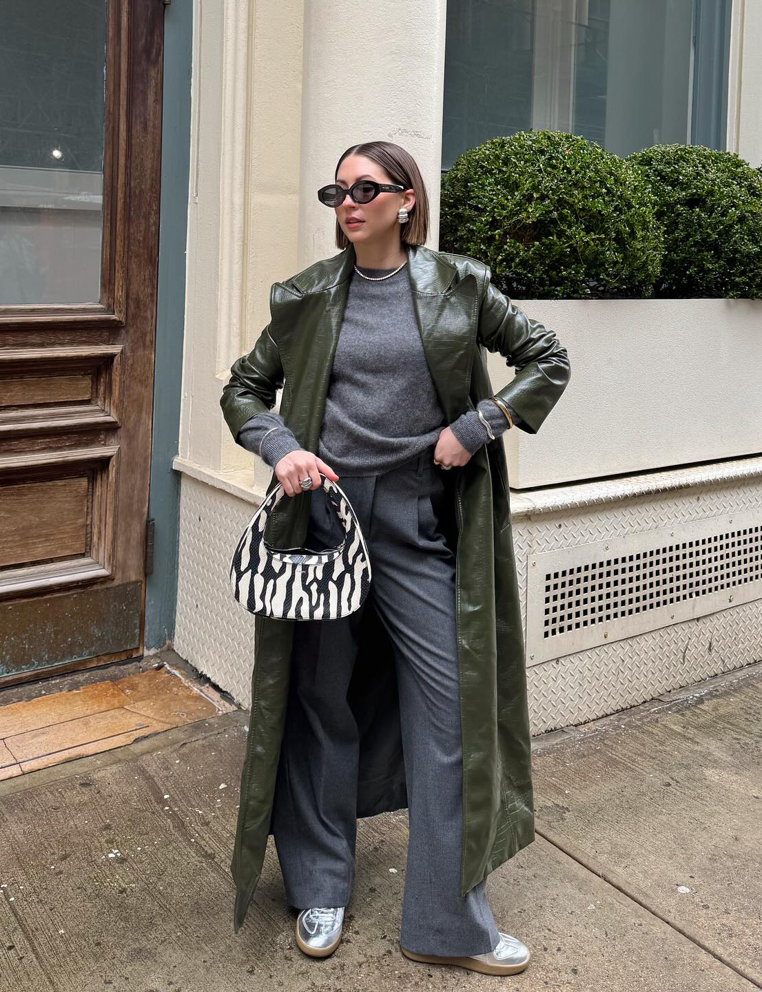 @trendingwithtinsley wears a grey outfit with a green coat and silver trainers