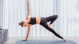 Woman performing yoga routine on yoga mat