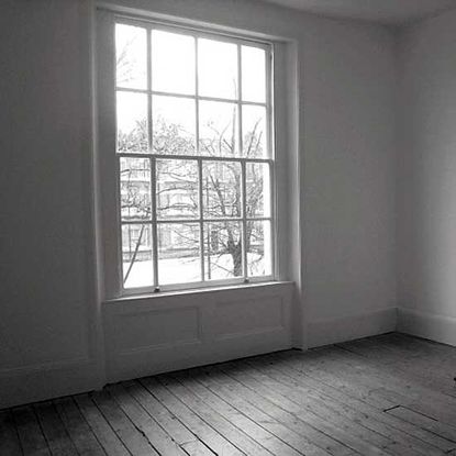white wall with and wooden floor and large window