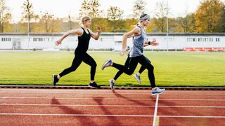 Women sprinting along a running track together