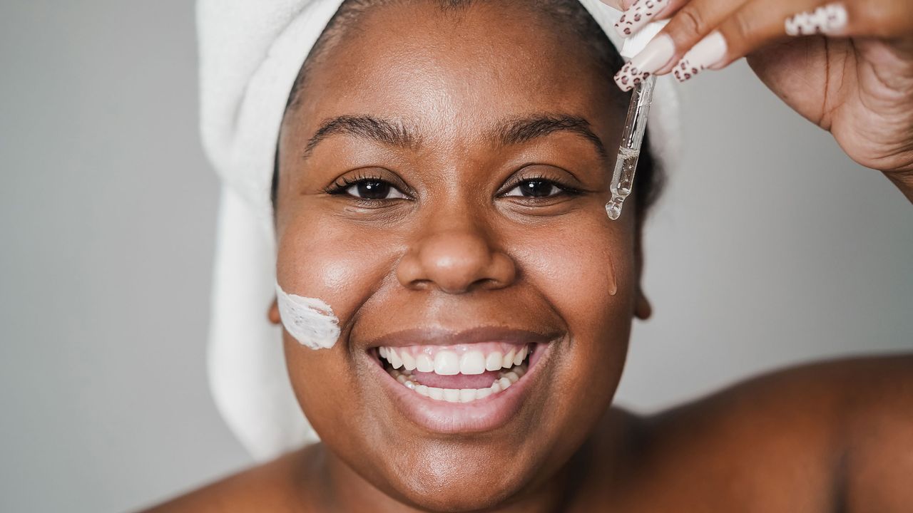 Young woman applying hyaluronic drop and skin mask beauty treatment on her face.