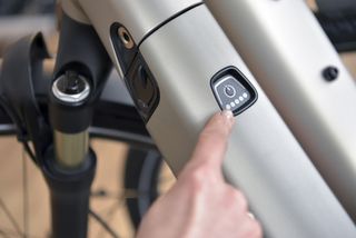 Finger pointing on switch of an e-bike