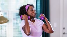 Woman performs biceps curls with a pair of 2kg dumbbells