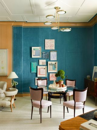 a dining room with yellow and blue wallpaper, a gallery wall and hidden door inset into the wallpaper