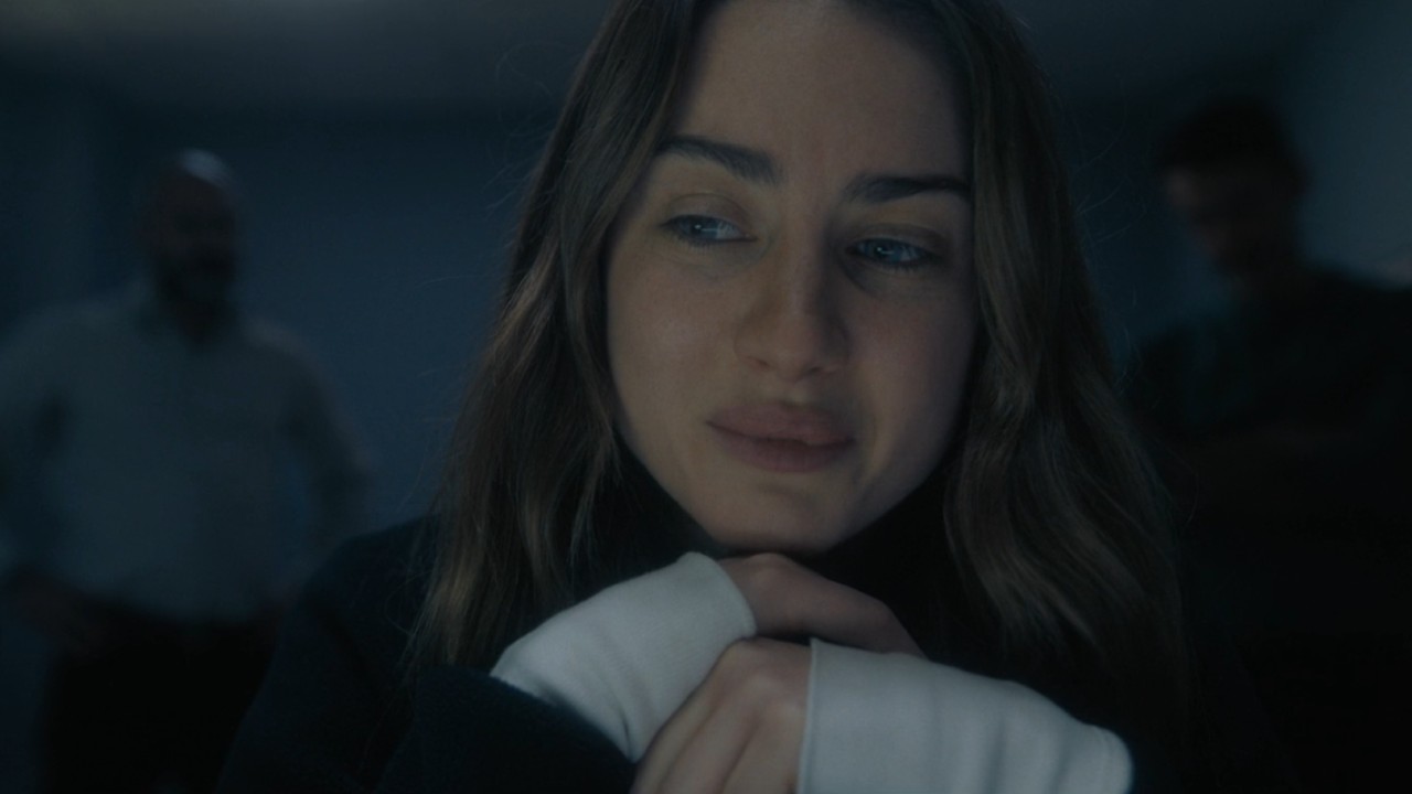 Grace Van Patten as Amanda Knox crying and placing her chin on her hands.