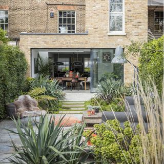 Exterior of Georgian townhouse with garden seating area and large standard anglepoise lamp