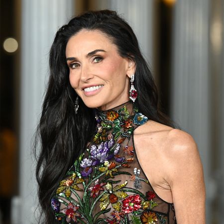 a close up photo of a white woman with long dark hair posing for paparazzi at a red carpet event