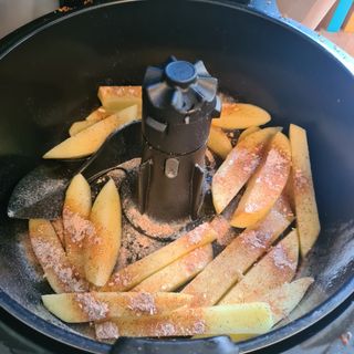 chips in the air fryer with seasoning ready to be cooked