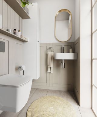 Bright and modern small bathroom featuring soft wood panelling, a sleek wall-mounted sink, floating toilet, and stylish gold-framed mirror.