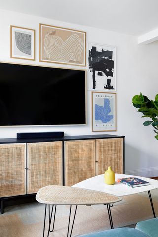 TV on wooden console as part of a gallery wall
