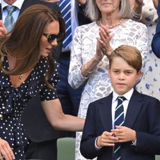 Kate Middleton wears a polka dot dress and sunglasses and talks to son Prince George who wears a navy suit with a striped tie