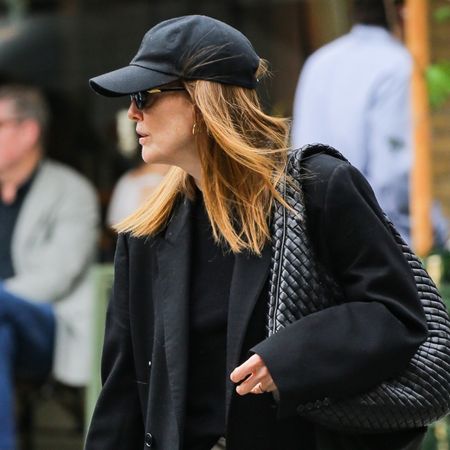 Julianne moore wears a baseball cap and a black blazer with a bottega veneta bag.