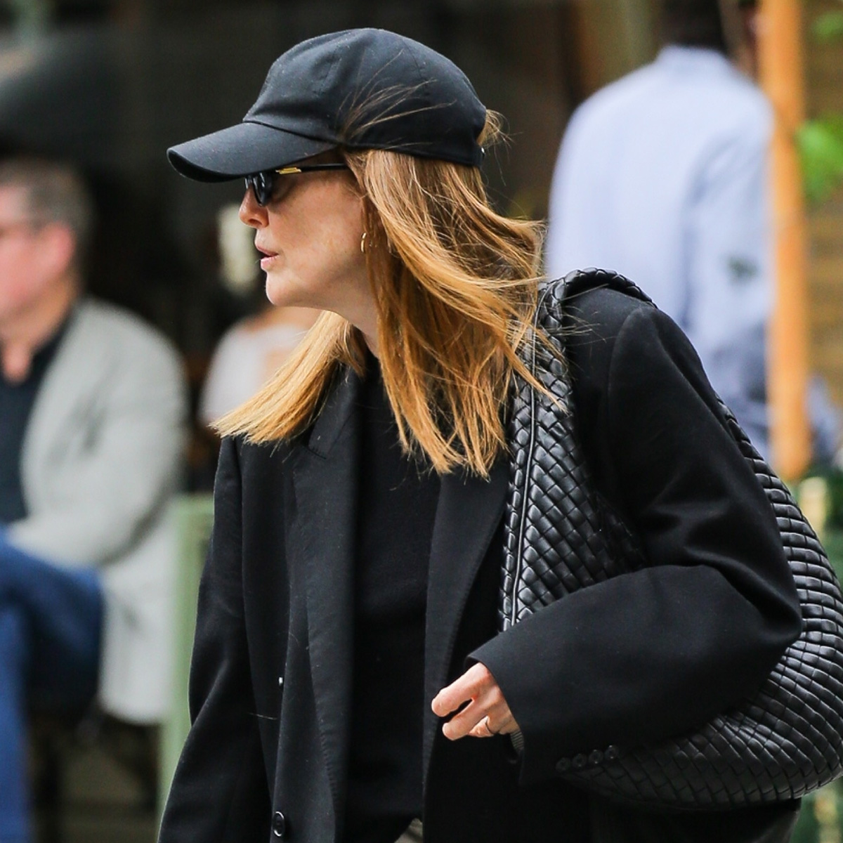 Julianne moore wears a baseball cap and a black blazer with a bottega veneta bag.