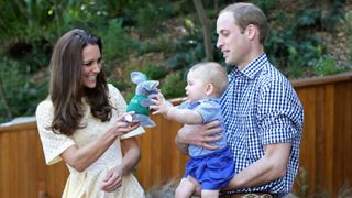 M&S spring shirt dress, Prince William, Duke of Cambridge holds Prince George of Cambridge as Catherine, Duchess of Cambridge gives him a toy bilby during a visit to the Bilby Enclosure at Taronga Zoo on April 20, 2014 in Sydney, Australia