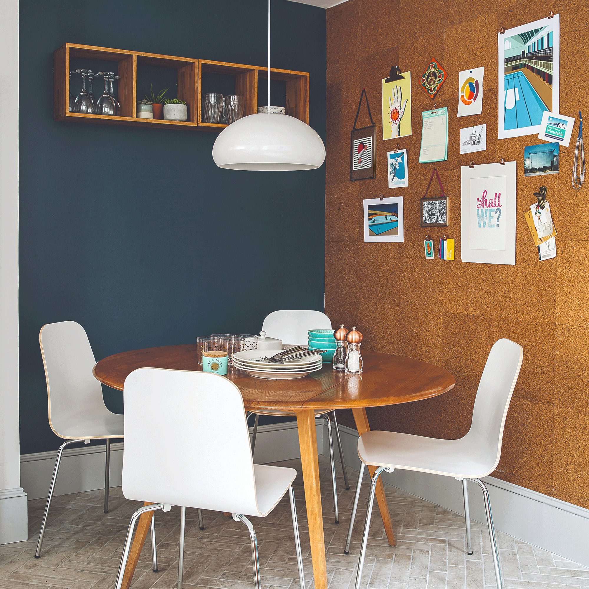 Blue wall with wooden table and white pendant light