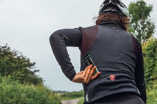 Female cyclist taking a sports nutrition bar out of her jersey pocket
