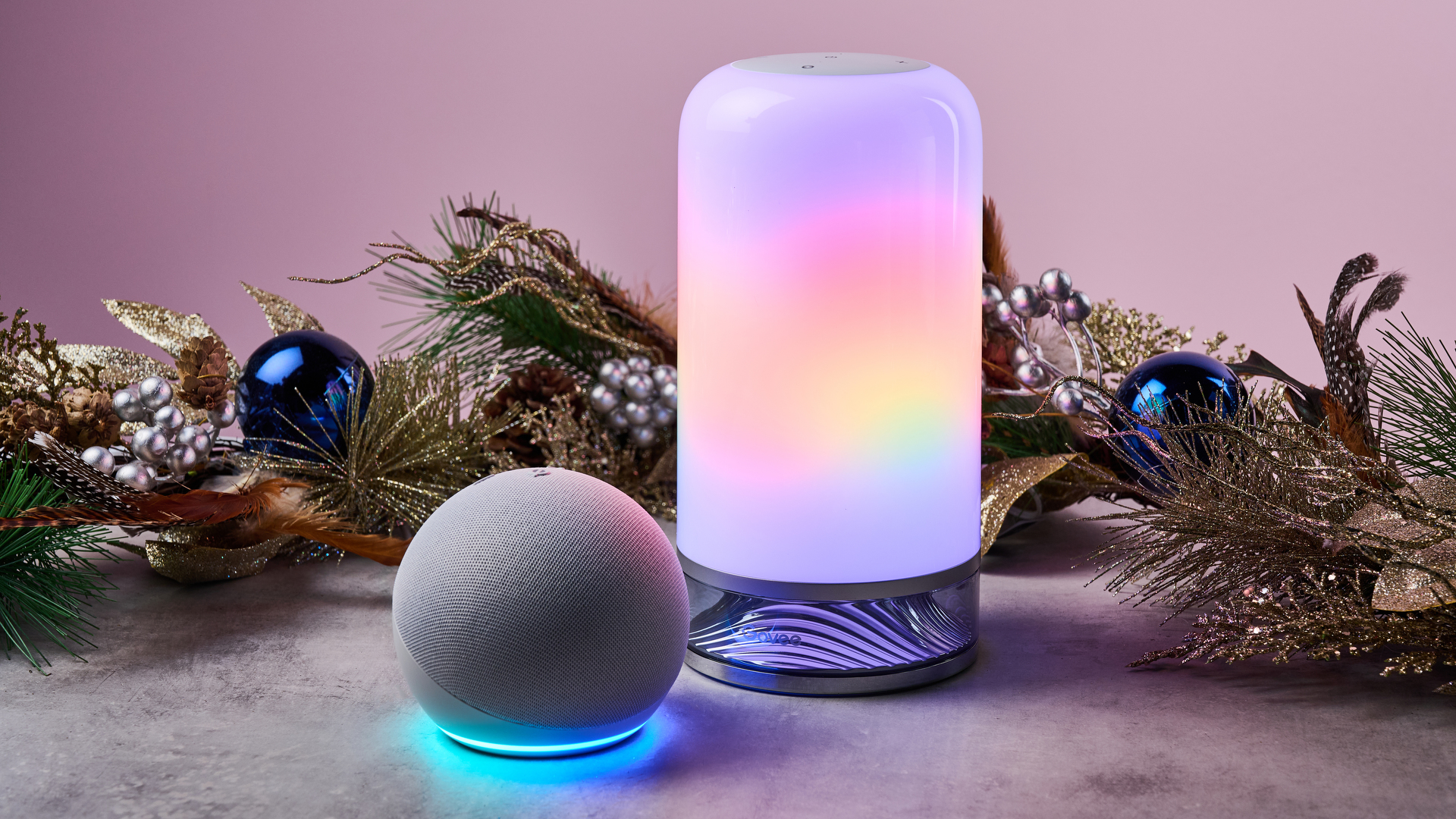 An Amazon Echo Dot and Govee Table Lamp 2 are pictured in front of a festive garland.