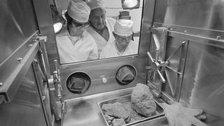 At the Manned Spacecraft Center's Lunar Receiving Laboratory in an secluded section geologists Don Morrison (left) and Fred Horz (right) and University of Texas geologist/professor William (Bill) Muehlberger inspect a special rock from the Apollo 16 mission.