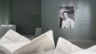 White chairs, photo and memoir of Pierre Paulin on the wall at Sotheby's