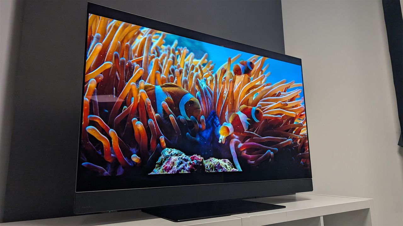 The Panasonic Z90B 48-inch OLED TV on a TV cabinet seen at a slight angle from the left side and a little lower than the TV. On screen is a scene from Netflix's Our Oceans.