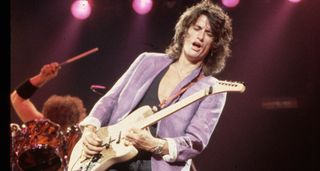 Joe Perry wears a lilac blazer as he plays a hot-rodded T-style onstage with Aerosmith in 1986