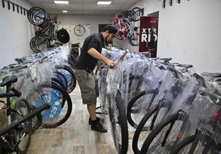 A mechanic prepares bikes in a shop storage area 