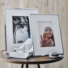 Side table with photo frames on and a wood background