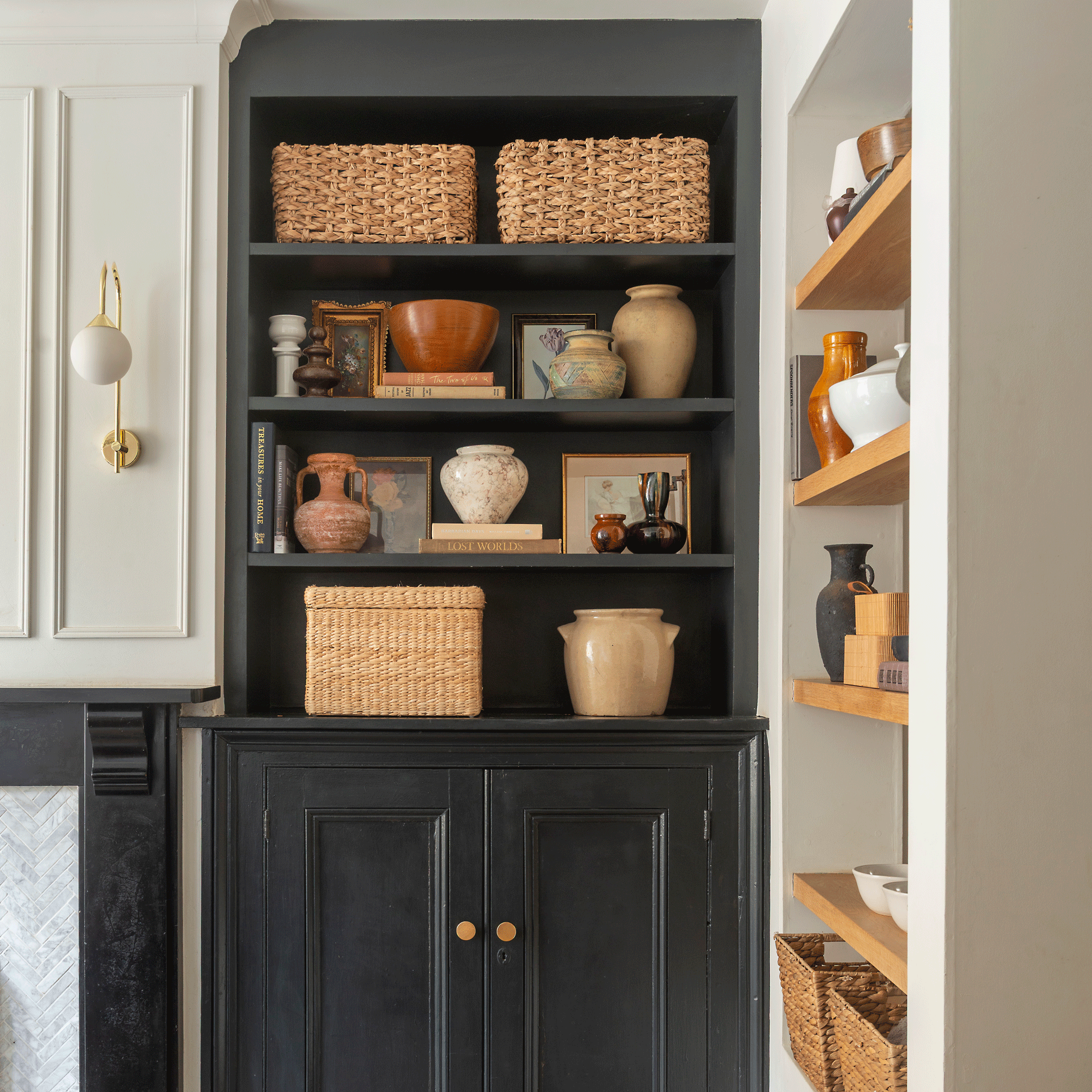 a built in black alcove shelving unit with shelves and a cabinet at the bottom
