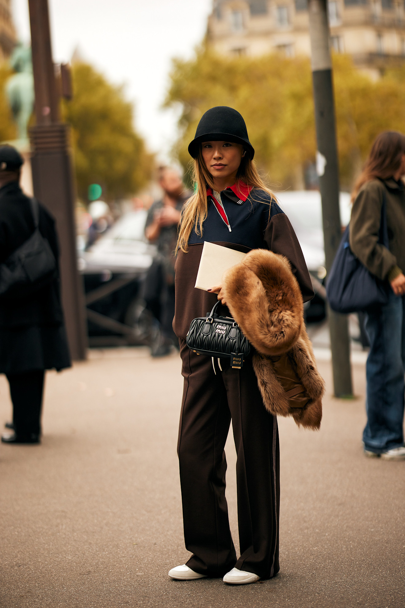 @nlmarilyn wears trench coat, black bag and white trainers