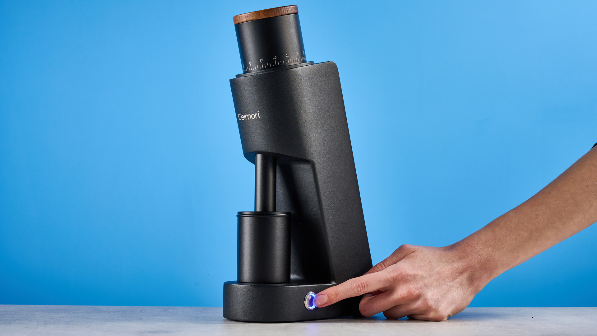 the wirsh geimori gu38 coffee grinder in black with a walnut hopper lid photographed against the blue tom's guide background